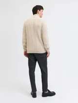 Sweater tejido de punto con diseño de ochos, color beige, con cuello alto y cierre frontal parcial.