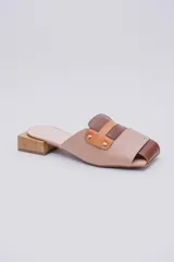 Mules de cuero color beige con detalles en marrón y suela de madera.