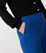 Pantalón de vestir rojo con corte cigarette, bolsillos delanteros y aberturas laterales en el ruedo.