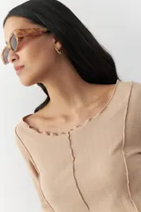 Remera blanca de manga larga con cuello redondo y costuras a la vista.