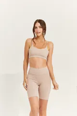 Top deportivo color beige, con breteles regulables, espalda recta y logo ZN.