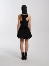 Top negro de lycra con escote halter, silueta entallada al cuerpo con ballenas, forrado con tejido tipo remería y espalda semi descubierta con cierres a la vista.