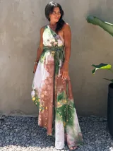 Vestido largo verde con diseño estampado tipo tie-dye y detalles dorados, de corte fluido, un solo hombro y diseño amplio.