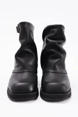 Botin de cuero vacuno color marrón con diseño de caña arrugada, punta redondeada y suela de plataforma negra con taco cuadrado.