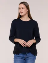 Remera negra de silueta recta y escote redondo, confeccionada en algodón y elastano. Presenta mangas tres cuartos y apliques de guipure calado en los laterales del ruedo.