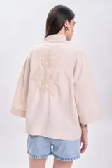 Kimono color crudo con bordado floral en la espalda, cuello mao y mangas 3/4 amplias.