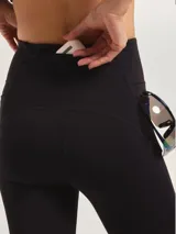 Calza deportiva negra de tiro alto, con paneles de tul transparente en la zona de los muslos y logo pequeño en la pierna.