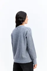 Buzo de punto de textura suave, color malva, con cuello redondo y diseño de calce relajado.