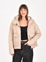 Campera acolchada color beige con diseño de costuras onduladas, cierre frontal, capucha desmontable y bolsillos frontales con solapa.