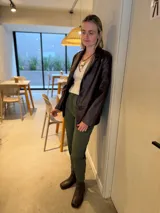 Blazer de cuero sintético en color marrón oscuro, con cierre frontal de dos botones y solapas clásicas.