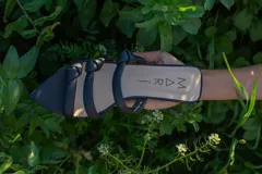 Sandalias negras de cuero con punta fina y tiras finas con nudos.