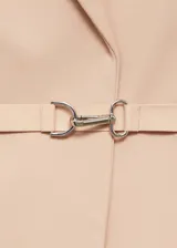 Abrigo largo de diseño oversize en color beige, confeccionado en tejido mezcla de lana. Presenta cuello con solapas, hombros estructurados y pronunciados, manga larga y dos bolsillos laterales con solapa. Incluye un cinturón fino ajustable en la cintura y abertura posterior en el bajo.