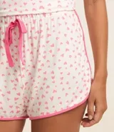 Short de pijama blanco con estampado de corazones rosas y ribete rosa.