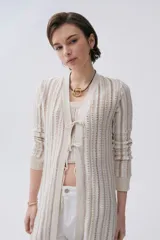 Sacón largo de tejido de punto con rayas verticales en tonos azul, rosa, amarillo y negro. Tiene mangas largas, cuello en V y cierre frontal con lazos.