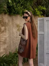 Vestido corto gris con bordado de flores en el frente.