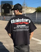 Remera oversize negra con diseño gráfico estampado en el pecho y en la espalda con inscripciones y líneas rojas.