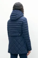 Campera azul marino con diseño capitoneado de rombos, cierre frontal con cremallera y capucha.