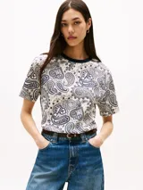 Remera de manga corta con cuello redondo ribeteado en azul marino. Presenta un estampado integral de cachemira (paisley) en tonos azul marino y blanco crema.