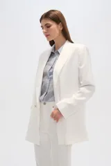 Blazer blanco de corte holgado, con cuello solapa, doble botonadura y bolsillos delanteros.