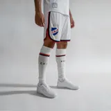 Short de fútbol oficial del Club Nacional de Football, temporada 2024, para hombre. Color blanco con detalles en azul y rojo en los bordes y el escudo del club bordado.