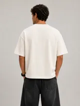 Remera boxy de algodón pesado color off white, de corte holgado y mangas cortas amplias.