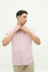 Camisa de manga corta confeccionada en una mezcla de lino y algodón, con cuello clásico, cierre frontal de botones y bolsillo en el pecho con logo bordado.