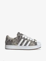 Zapatillas Adidas Superstar ST con exterior de diseño texturizado símil animal print de serpiente en tonos grises y tostados, combinados con las icónicas tres tiras blancas, cordones anchos y la clásica puntera de caucho en color blanco.