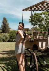 Conjunto de dos piezas compuesto por un chaleco corto con botones frontales y una falda corta tipo short con diseño cruzado, ambos con estampado de rayas verticales.