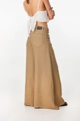 Pantalón de lino verde militar, de tiro alto y corte amplio con botamanga ancha. Cuenta con bolsillos delanteros aplicados y cierre frontal con botón y bragueta.