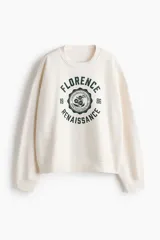 Buzo de corte oversized con cuello redondo, mangas largas de hombros caídos y puños acanalados. Presenta un diseño estampado frontal con la inscripción Florence Renaissance y un motivo floral central.