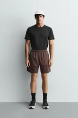 Pantalones deportivos cortos de tejido técnico ligero y elástico, con cintura elástica ajustable, bolsillos frontales y aberturas laterales en el bajo.