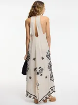 Vestido largo color beige con breteles finos y bordado de motivos geométricos en negro.