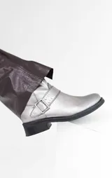 Bota corta de cuero color peltre, con hebilla lateral y suela track.