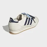Championes Adidas SL 72 OG de color beige, con las icónicas tres tiras y detalles en azul marino. Cuentan con suela de caucho texturizada y doble cordón en tonos celeste y azul con puntos blancos.