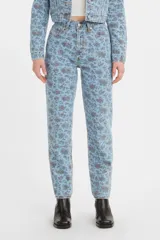 Pantalón de jean estilo mom, de tiro alto, con estampado floral en tonos azules y rosados sobre base celeste.