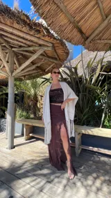 Ruana de tejido de punto color crema con diseño de líneas horizontales caladas y terminación con flecos en el ruedo.