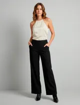 Pantalón de vestir de corte wide leg color negro, con cintura alta, detalle de botones decorativos en la parte frontal y bolsillos laterales.