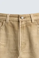 Pantalón straight fit de algodón con efecto lavado y roturas localizadas. Presenta diseño de cinco bolsillos, cierre frontal con cremallera y botón metálico.