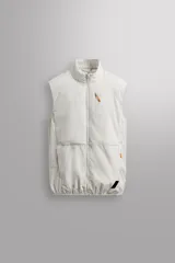 Chaleco técnico de corte regular con cuello subido y cierre frontal de cremallera. Presenta un diseño ligero con panel frontal ligeramente acolchado, bolsillos laterales con cremallera oculta y un bolsillo adicional en el pecho con tirador en color naranja. Incluye acabados con cinta elástica en el bajo y detalle de logo estampado.