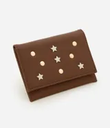 Billetera pequeña tipo sobre color marrón, confeccionada en cuero sintético. Presenta apliques decorativos metálicos en forma de estrellas y círculos en la parte frontal.