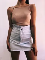 Crop top negro con textura brillante, breteles anchos con volados y espalda descubierta que se ata con lazos.