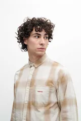 Camisa a cuadros beige y blanco, de manga larga y corte clásico.