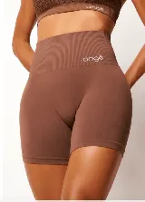 Short deportivo de tiro alto con tecnología seamless, confeccionado en tejido de compresión color marrón. Presenta una cintura ancha acanalada con logo bordado y diseño texturizado que realza la silueta.