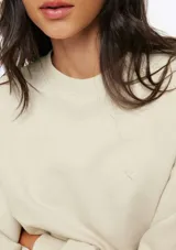 Buzo de cuello redondo y manga larga, confeccionado en tejido de punto fino con diseño liso y corte holgado.