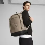 Mochila Puma color tostado con detalles en negro. Tiene dos compartimentos principales con cierre, un bolsillo frontal con cierre, dos bolsillos laterales de malla y logo de Puma en relieve.