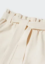 Short de tiro alto confeccionado en una mezcla de algodón y lino. Presenta un diseño recto y corto, con cintura elástica y un lazo desmontable para ajustar. Incluye dos bolsillos laterales.