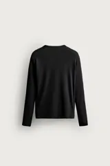 Camiseta de manga larga con cuello redondo, confeccionada en tejido con estructura de canalé y corte relajado.