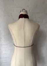 Top color borgoña con cuello halter y lazo ajustable en el frente.