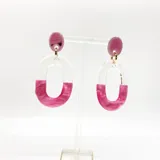 Aros colgantes de resina transparente y fucsia con forma de eslabón ovalado.