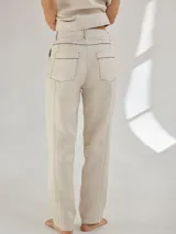 Pantalón largo negro de lino, corte cigarette, con bolsillos laterales y traseros. Presenta costuras a contratono en color crudo.